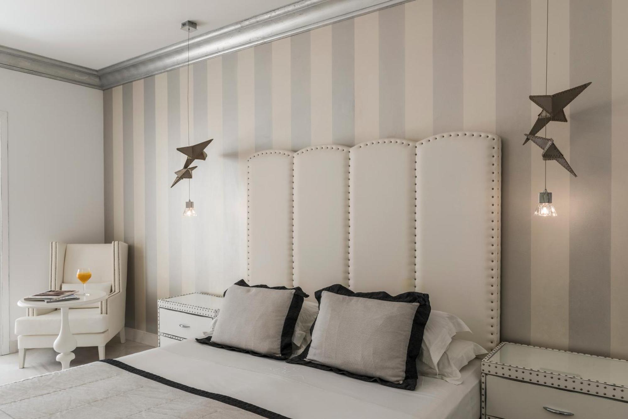 미트시스 알릴라 리조트 앤 스파 팔리라키 객실 사진 A bedroom with a bed, a nightstand, a chair, and a lamp